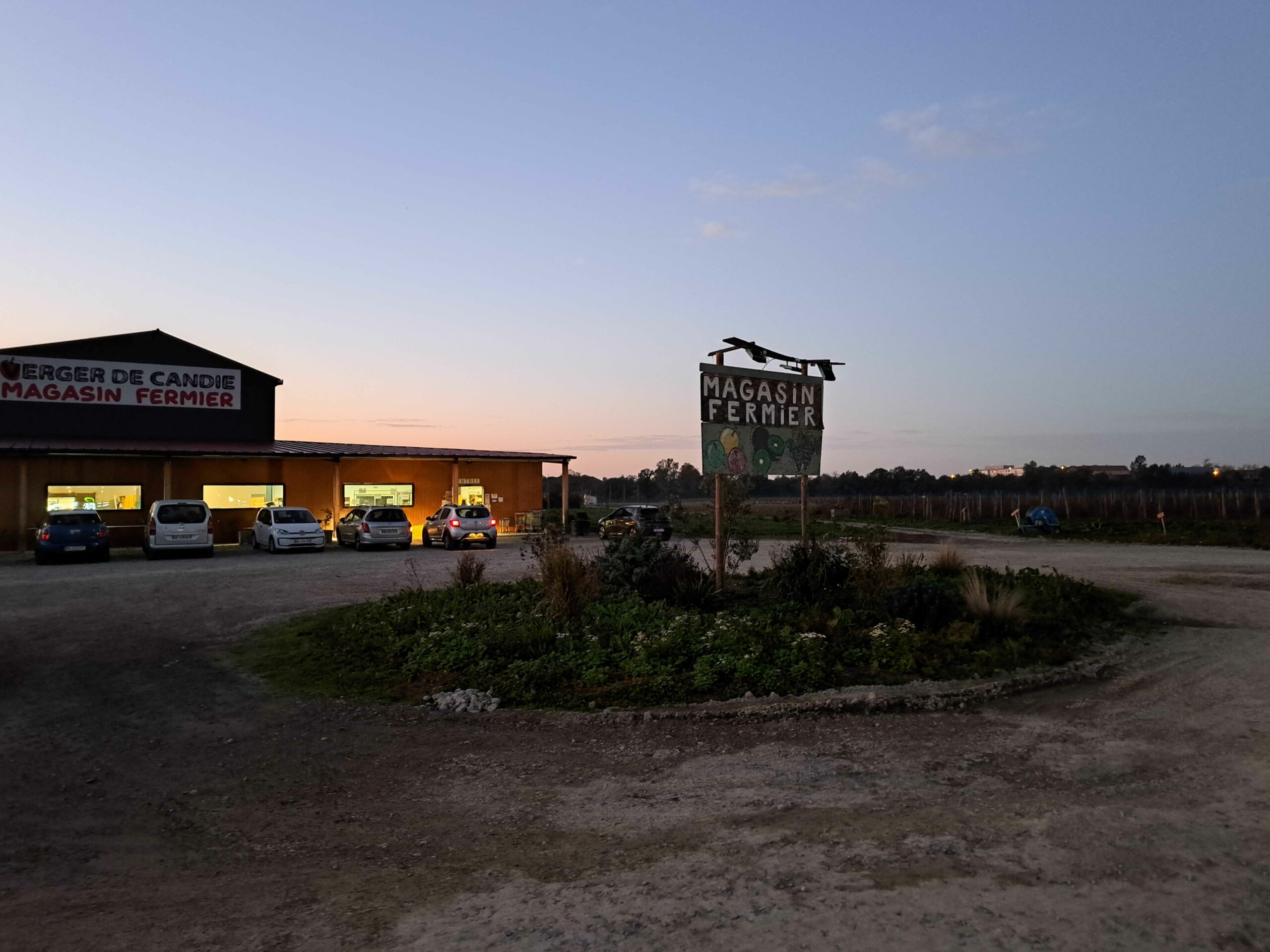 Vue du parking de l'entrée du magasin et du Vergé de Candie.